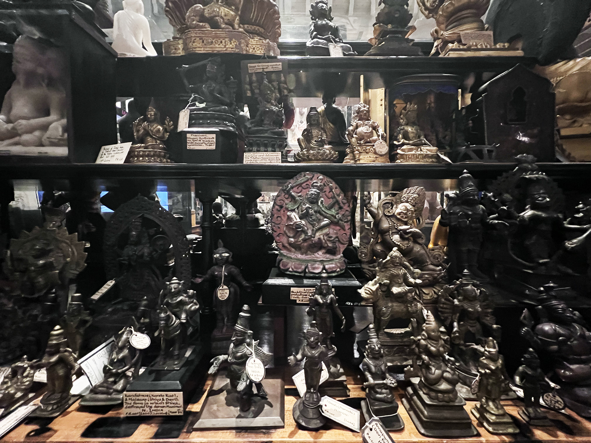 Small religious sculptures stacked in a display case