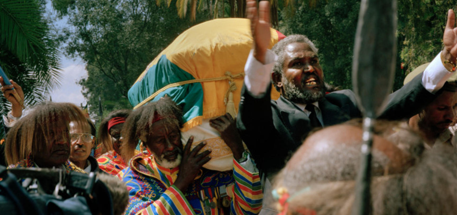 Veteran soldiers carry the Emperor’s coffin towards Trinity Cathedral, as a man calls out praises. Addis Ababa, Ethiopia. Photograph by Peter Marlow. 2000.