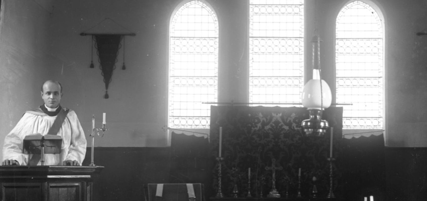 Glass negative showing Harley standing in the pulpit of an unidentified church.