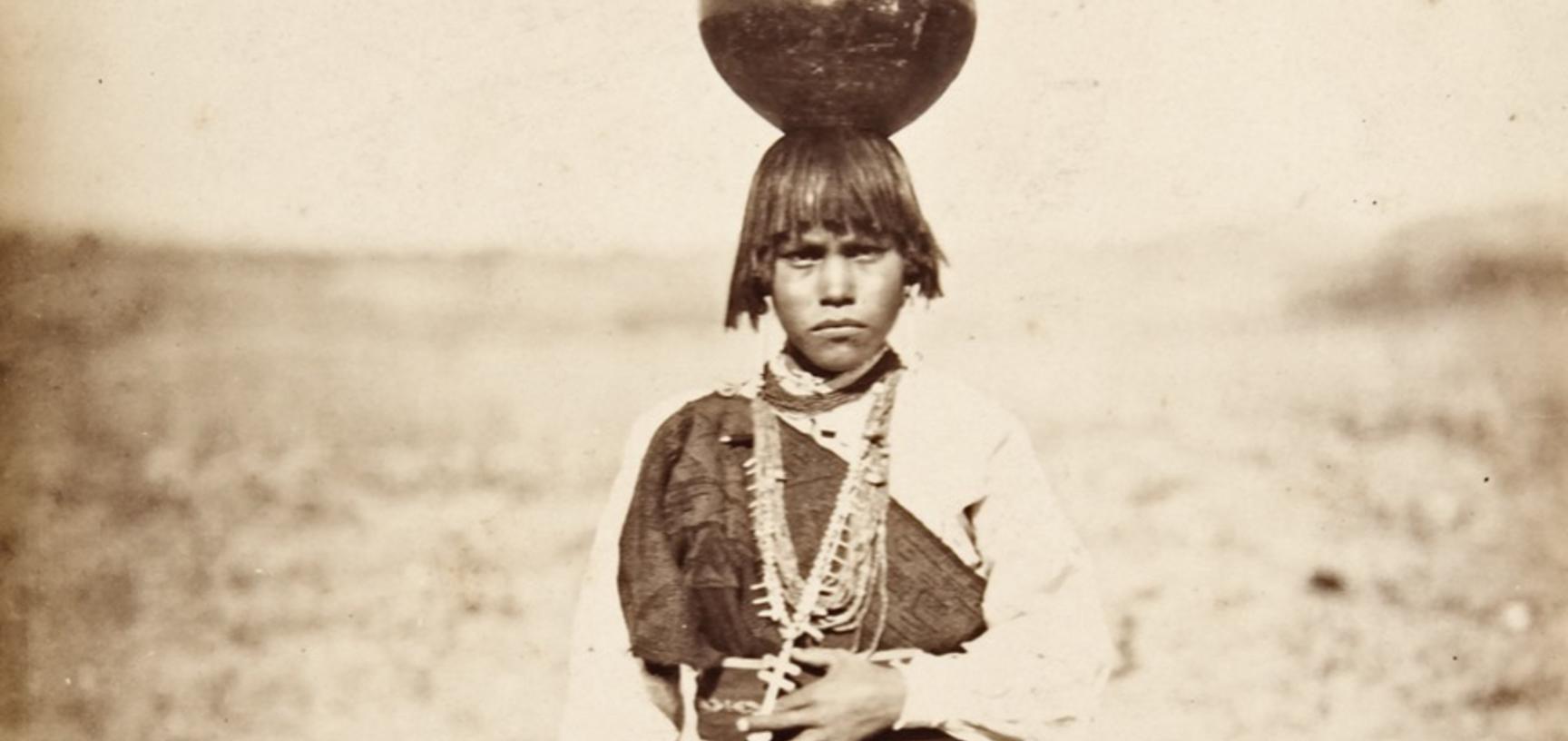 Pabla Tafolla, dressed in a woollen manta of local manufacture, carrying a blackware water jar on her head. 