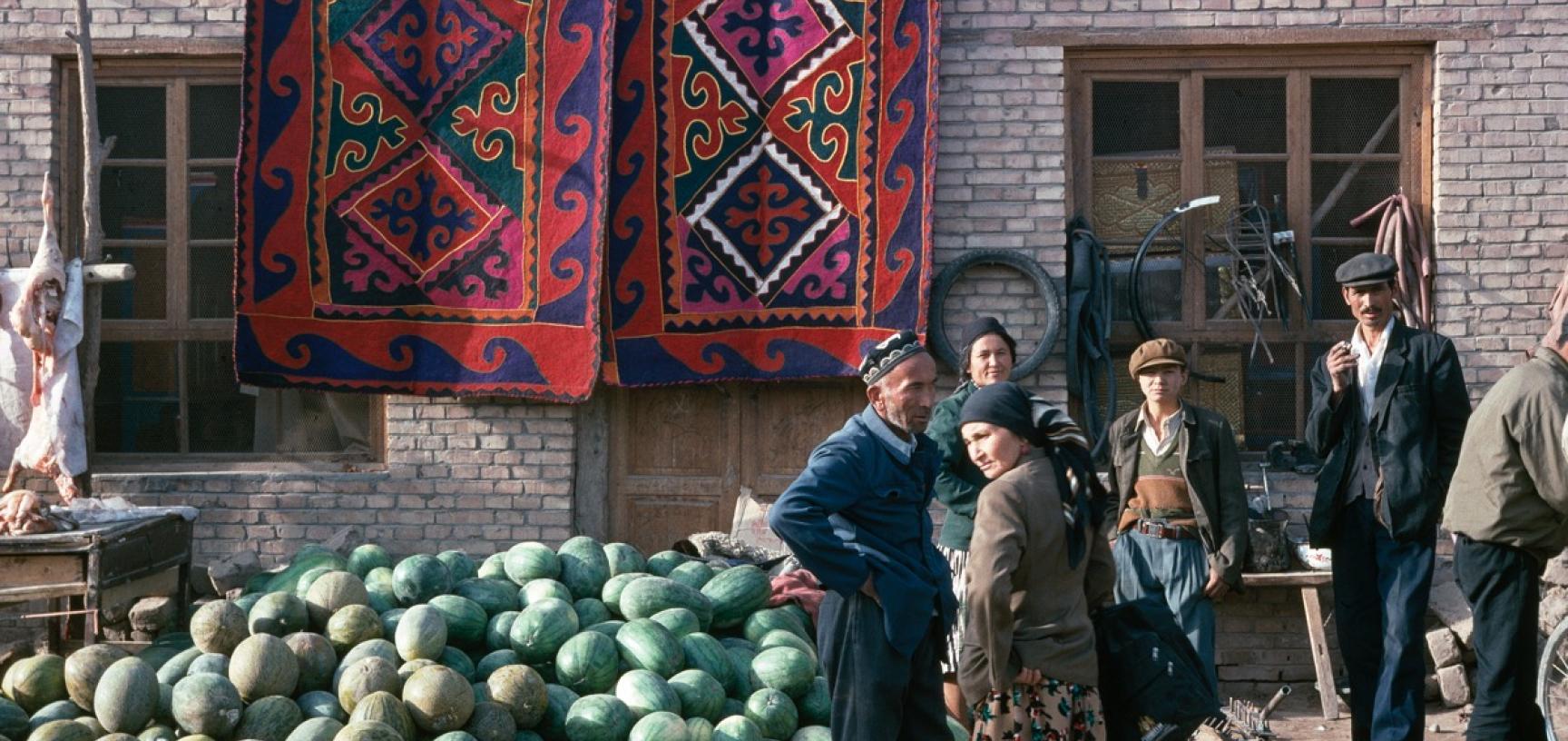 People at a market stall selling watermelons