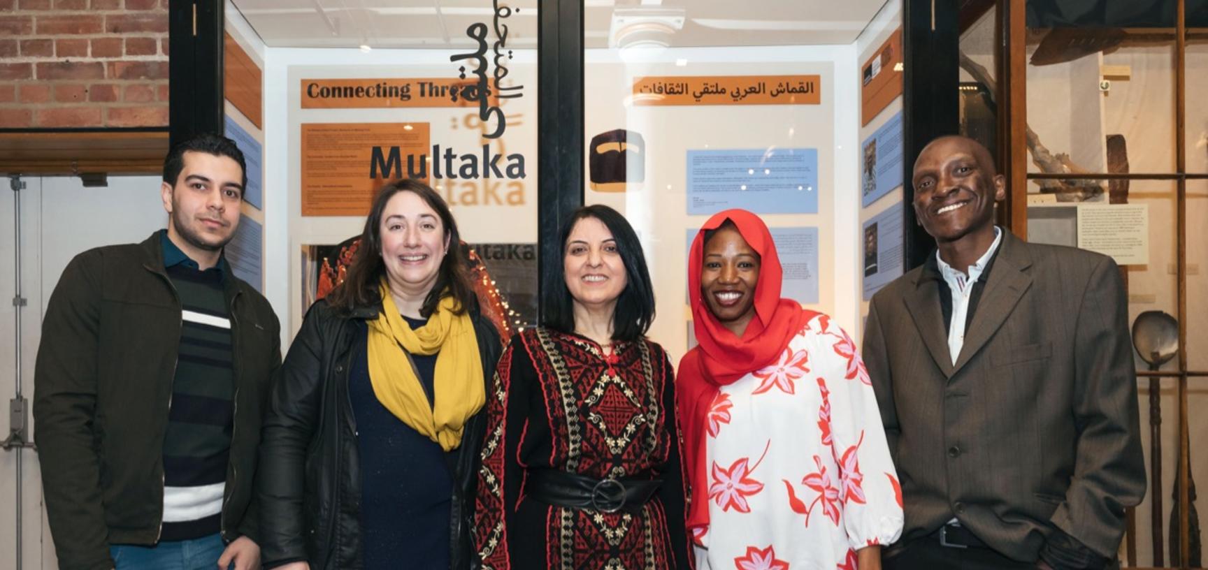 Multaka-Oxford volunteers and co-curators of the ‘Connecting Threads’ exhibition pictured in front of the display case.
