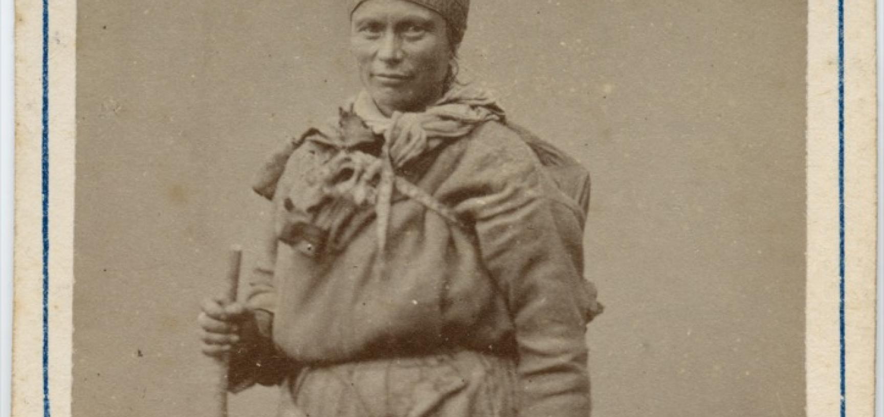 Studio portrait of a Saami woman, standing, holding a bag. Photograph by the Jørgen Wickstrøm studio. Tromsø, Norway. Circa 1870s. (Copyright Pitt Rivers Museum, University of Oxford. Accession Number: 1941.8.47)
