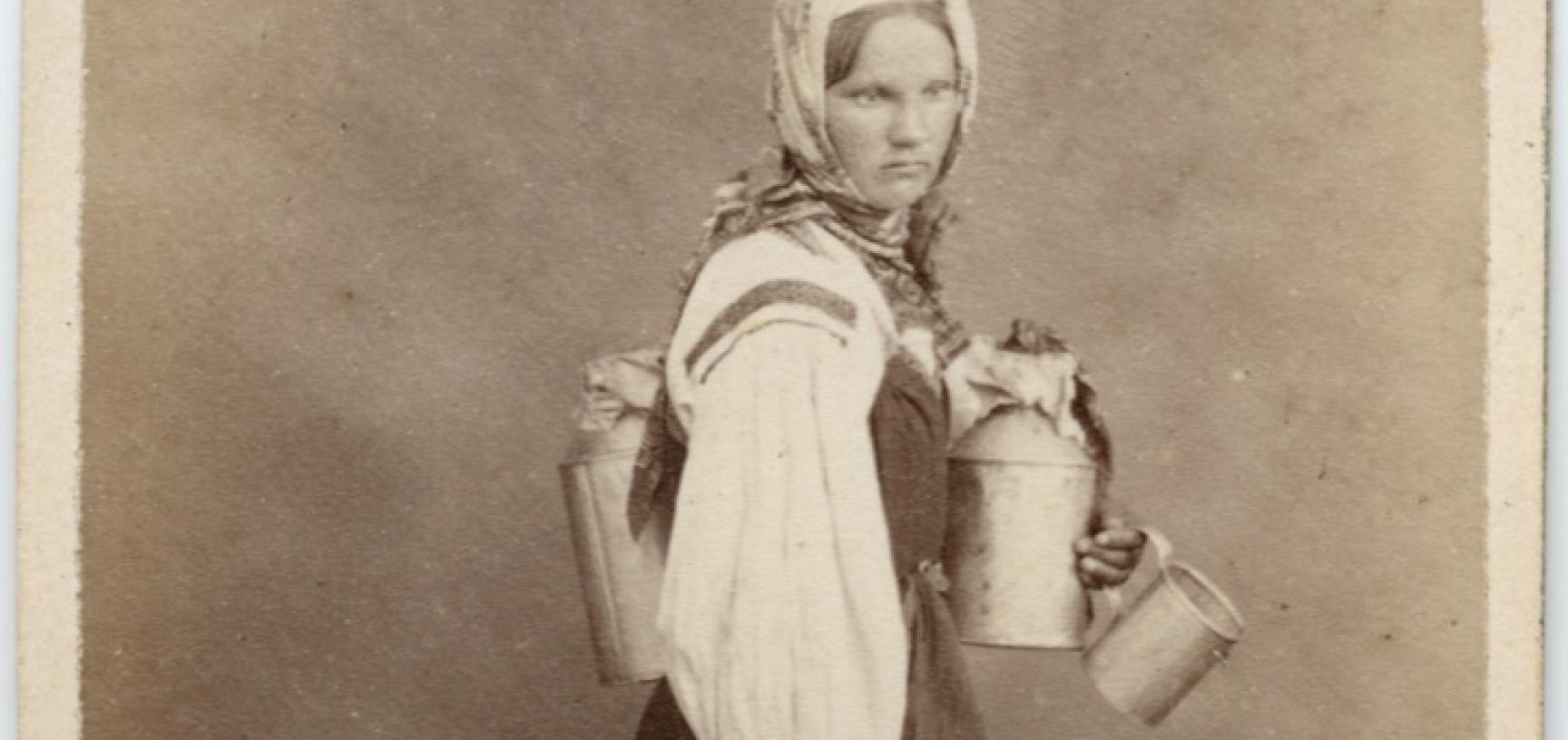 Studio portrait of a Finnish woman, a cream seller, standing, barefoot, carrying several metal jugs. Photograph by the William Carrick studio. St Petersburg, Russia. 1860s. (Copyright Pitt Rivers Museum, University of Oxford. Accession Number: 1941.8.135)