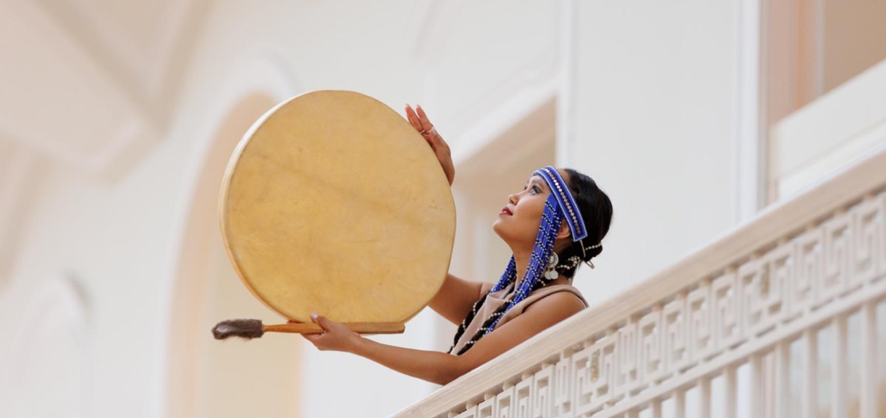 Galina Veretnova in traditional costume with her drum.