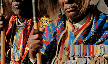 Veterans wearing lion’s mane headdresses and military service medals forming a guard of honour for the Emperor’s coffin on its way to Trinity Cathedral. Addis Ababa, Ethiopia. Photograph by Peter Marlow. 2000.