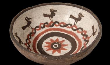 Small eating bowl made in Zuni Pueblo with painted decoration of birds and a sunflower in the centre, collected by James Stevenson for the United States Geological Survey.
