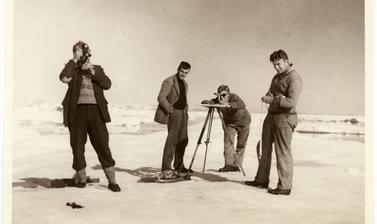Group portait of expedition members L. R. Wagner, Augustine Courtauld, Alfred Stephenson and Wilfred Hampton posing with surveying equipment. Photograph by Henry Iliffe Cozens. Greenland. 1930–1931.