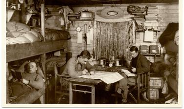 Members of the expedition posed and looking studious in their base hut. 