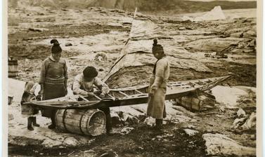 One of the various stages in the construction of a kayak by Inuit, here showing the sewing of a taut sealskin cover. Photograph by Henry Iliffe Cozens. Greenland. 1930–1931.