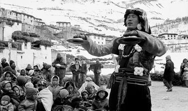 Gatuk Sonam, head Buchen from Mud, performs a stone breaking ceremony on top of a house in Lhalung. Photograph by Patrick Sutherland. Lhalung, Spiti, Himachal Pradesh, India. 2006.