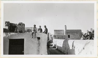 Children playing on the roof of a house in Santorini, Greece. 