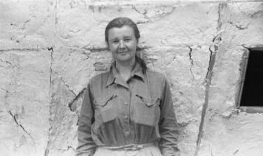 Portrait of photo Ursula Graham Bower standing next to a wall