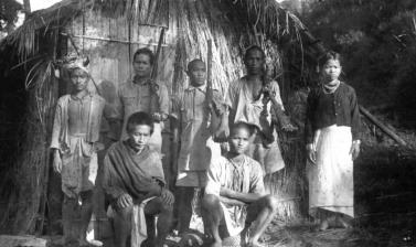Group portrait of six men and one women, three of the men are holding guns