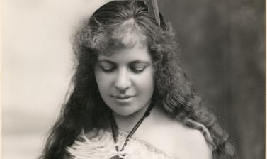 Signed portrait photo of a young women with eyes downcast