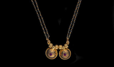 Long gold chain necklace with pendant in the form of two gold breasts