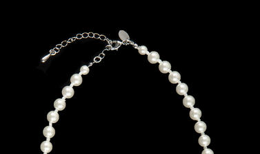 Necklace of white imitation pearls with a silver clasp