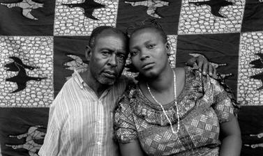 Couple posing in front of a printed cloth backdrop, probably for a marriage certificate photograph. Photograph by Jacques Touselle. Mbouda, Cameroon. 1987.