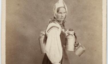 Studio portrait of a Finnish woman, a cream seller, standing, barefoot, carrying several metal jugs. Photograph by the William Carrick studio. St Petersburg, Russia. 1860s. (Copyright Pitt Rivers Museum, University of Oxford. Accession Number: 1941.8.135)