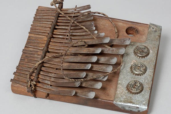 Mbira from Zimbabwe. Wooden with metal prongs & bottle caps.