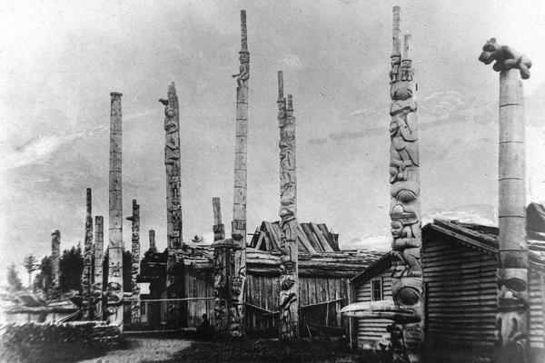 Photograph taken in 1882 showing totem pole in the Haida village of Masset