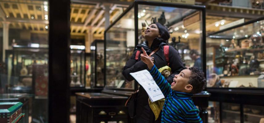 A family looking into a display case at the Pitt Rivers Museum