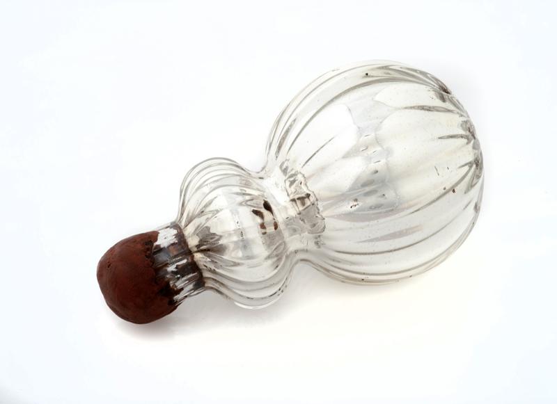 Silver glass bottle with a spherical base and resin stopper.