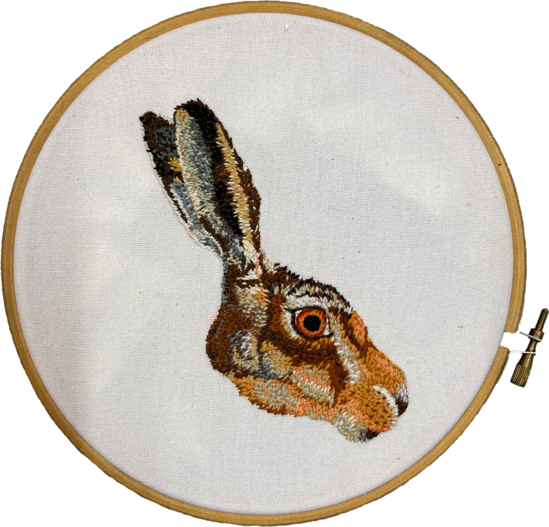 A detailed image of a hare's head facing to the right, made from lots of small stitches.