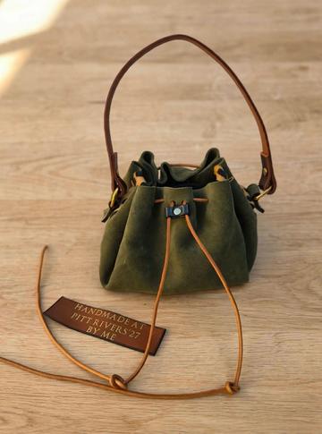 Green leather drawstring bag with brown straps