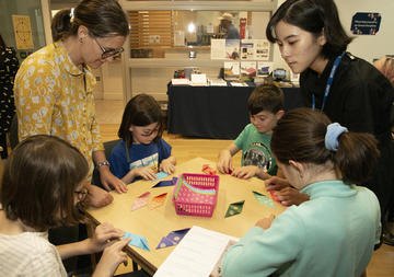 Four children and two adults doing craft activities