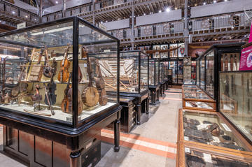 Rows of museum display cases containing musical instruments