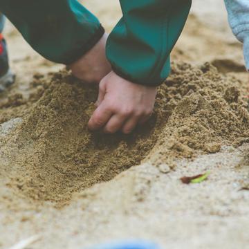 Hands scooping sand