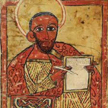 Detail from an early illustrated manuscript depicting the Evangelist Luke holding a page and a pen.