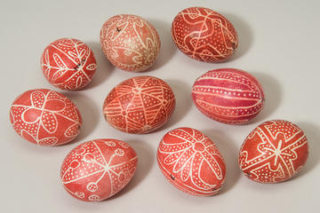 Nine eggs decorated with red and white painted designs