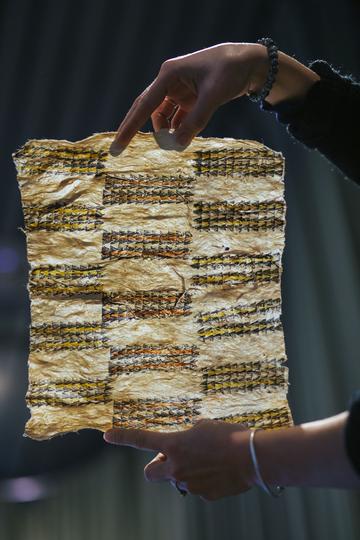  Strip of barkcloth being held up between two hands