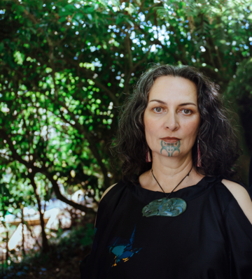 Portrait of Ariana Tikao with tree foliage in the background