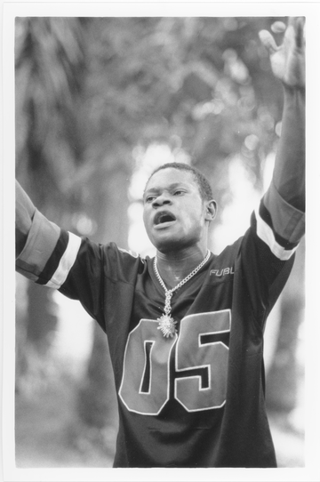 black and white photograph of a man wearing an American football shirt with arms raised