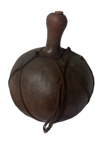 A round gourd that has been dried and made into a vessel, with rope wrapped around to form a handle